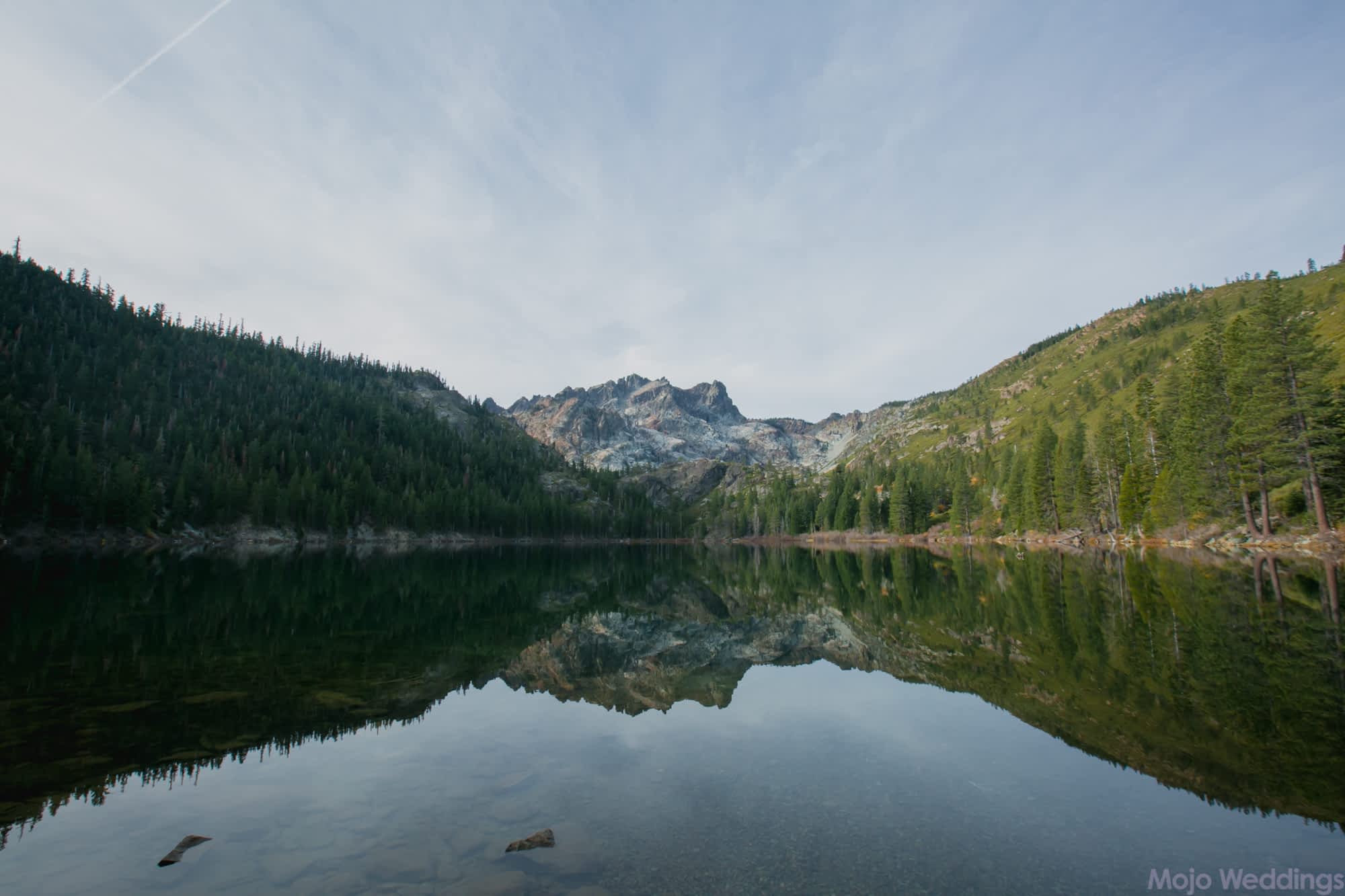 A mountain and trees are reflected in a lake.