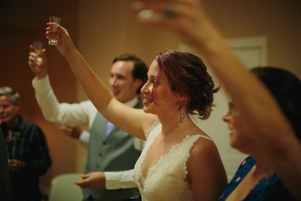 Bride and groom toasting with their family while doing a shot of tequila before their wedding ceremony.