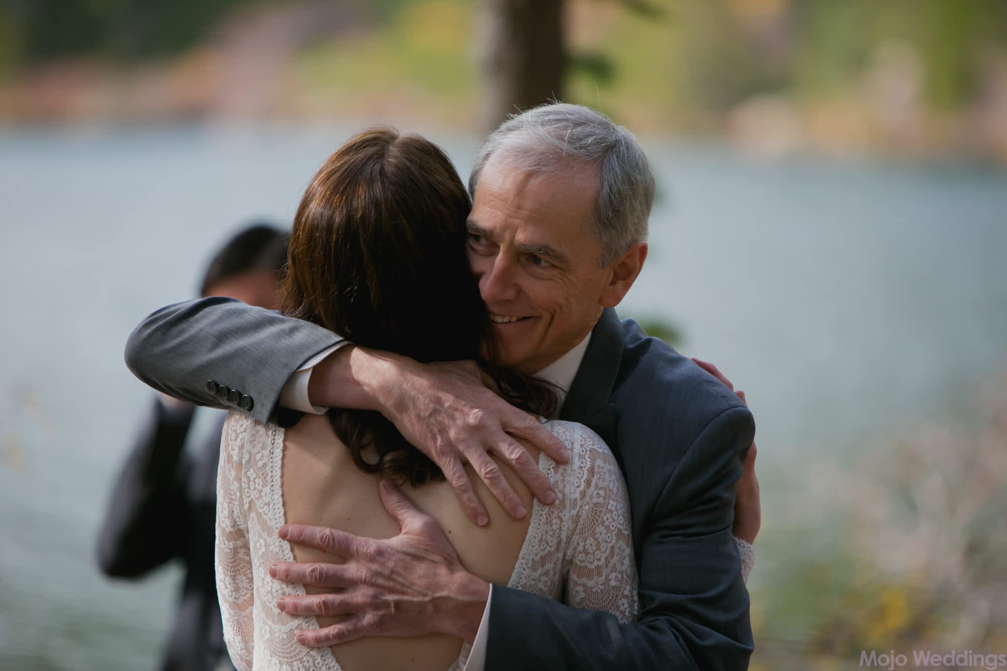 The father of the bride hugs his daughter.
